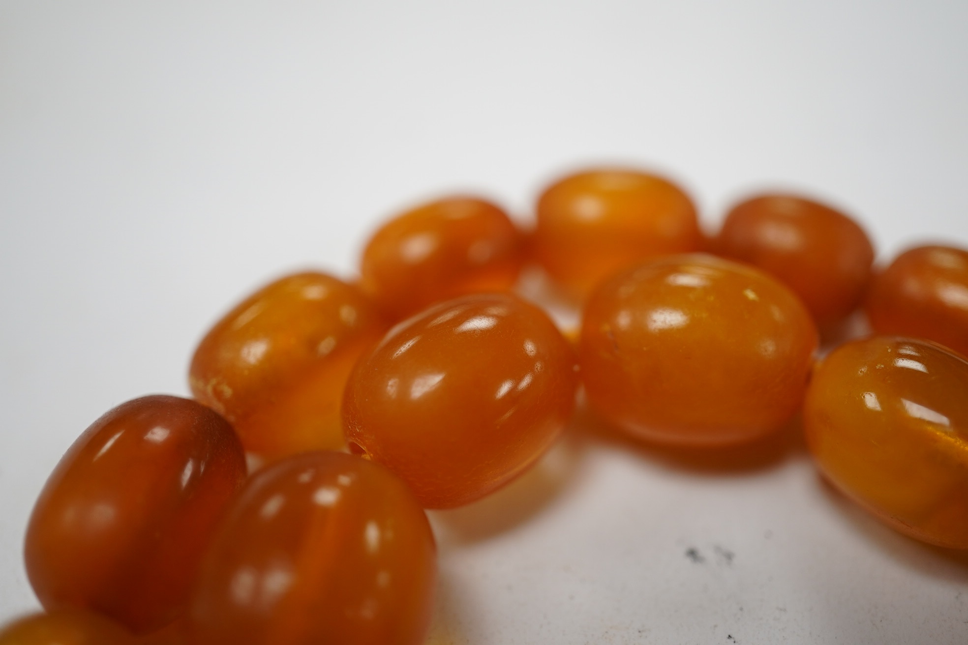 A single strand graduated oval amber bead necklace, 58cm, gross weight 34 grams. Condition - poor to fair